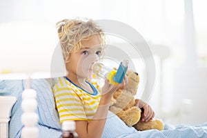 Sick little boy with asthma medicine. Ill child