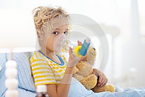 Sick little boy with asthma medicine. Ill child