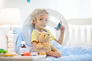 Sick little boy with asthma medicine. Ill child photo