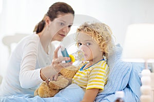 Sick little boy with asthma medicine. Ill child photo