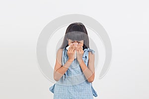 Sick little girl blowing her nose isolated on white