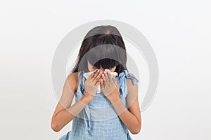 Sick little girl blowing her nose isolated on white