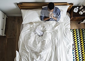 Sick man on bed blowing his nose