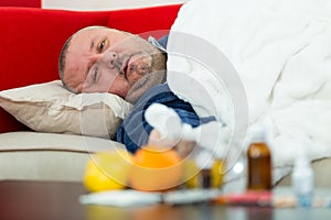 Sick man in bed with drugs and fruit on table