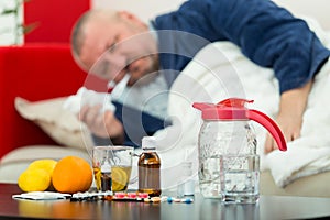 Sick man in bed with drugs and fruit on table