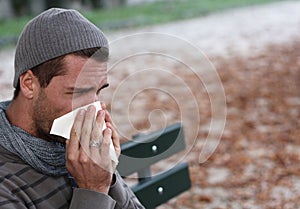 Sick man blowing nose