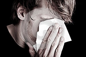 Sick man blowing nose