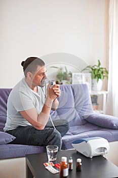 A sick man breathes through an inhaler mask