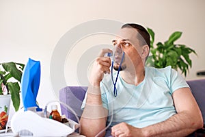 A sick man breathes through an inhaler mask