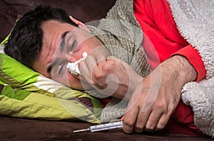 Sick man having flu and blowing her runny nose