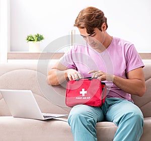 Sick man at home with first aid kit
