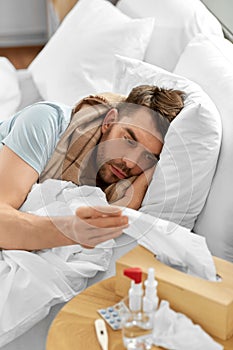 sick man lying in bed at home and taking tissue