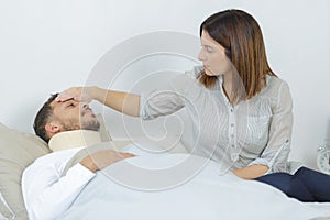 Sick man lying in bed at hospital and wife