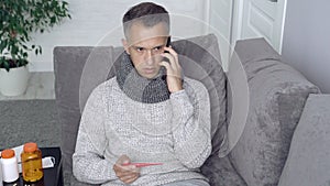 Sick man measuring body temperature and calling the doctor at home