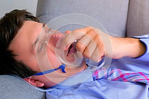 Sick man in oxygen mask due to difficulty in breathing in coronavirus pandemic.