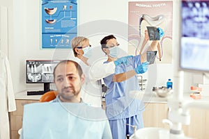 Sick man patient waiting for teeth examination sitting on dental chair