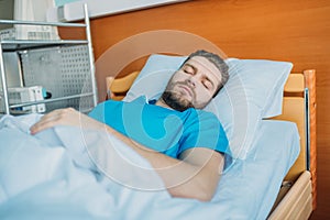 Sick man sleeping on hospital bed at ward, hospital patient bed