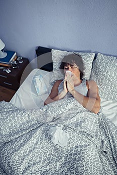 Sick man sneezing and covering nose with tissue