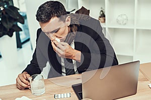 Sick Man in Suit with Scarf Sitting in Office.