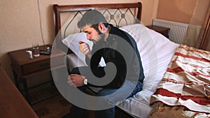 Sick man taking pill while sitting on bed. Dynamic shot