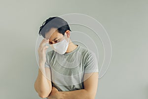 Sick man wearing white hygienic mask in grey t-shirt in concept of virus.