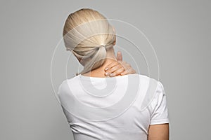 Sick mature blond woman suffering acute neck pain