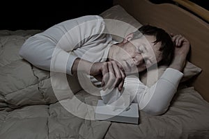 Sick mature man using tissue while in bed