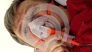 Sick middle-aged man is breathing through oxygen mask while lying in bed. Treatment of asthma, allergies, bronchitis