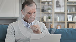 Sick Middle Aged Man Coughing while Working on Laptop at Creative Office