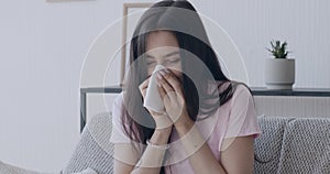 Sick millennial woman blowing her nose at home interior