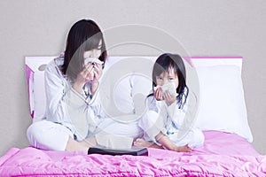 Sick mother and child wiping their nose