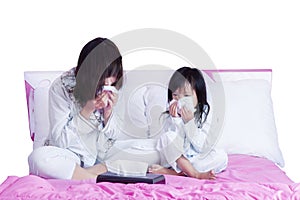 Sick mother and child wiping their nose