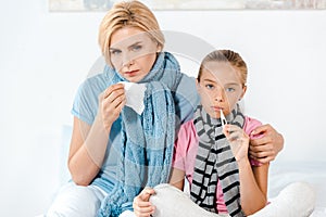 Sick mother holding tissue near ill kid