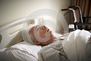 Sick old man lying in hospital bed