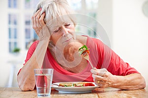 Sick older woman trying to eat