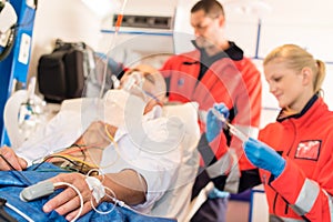 Sick patient with paramedic in ambulance treatment