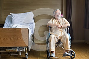 A sick person on a wheelchair in ward. Senior man in wheelchair with doctor in hospital