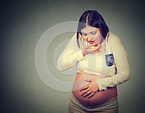 Sick pregnant woman with nausea morning sickness about to throw up photo