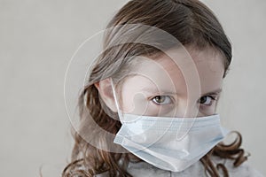 Sick sad little girl in medical mask with diagnosis coronavirus covid-19 wearing protective medical mask during epidemy outbreak