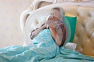 Sick senior have a cold,blowing nose in paper handkerchief  in bedroom,flu or the weather is changing,asian elderly sneezing in a