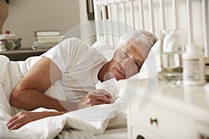 Sick Senior Man In Bed At Home