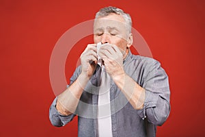 Sick senior man blowing his nose with tissue. having flu, aller
