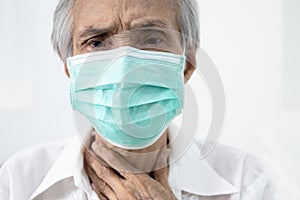 Sick senior in protective mask,old people has sore throat,cough,fever and phlegm in the throat,illness symptom of COVID-19 photo