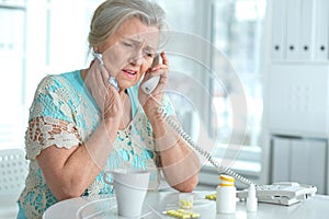 Sick senior woman calling to doctor