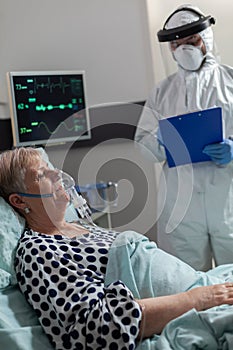 Sick senior woman inhale and exhale through oxygen mask