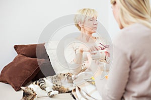 Sick senior woman lying resting in bed with her pet cat