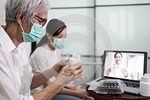 Sick senior woman making video call with doctor on laptop computer while stay home,elderly patient ask a doctor about illness and photo