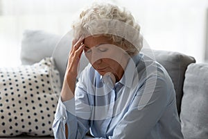 Sick senior woman touch head suffering from dizziness at home