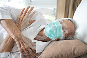 Sick senior woman wear a mask has a fever,shivering,high temperature,chilly,old people have a cold,flu,Tired elderly patient with