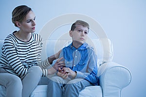 Sick son sitting on sofa